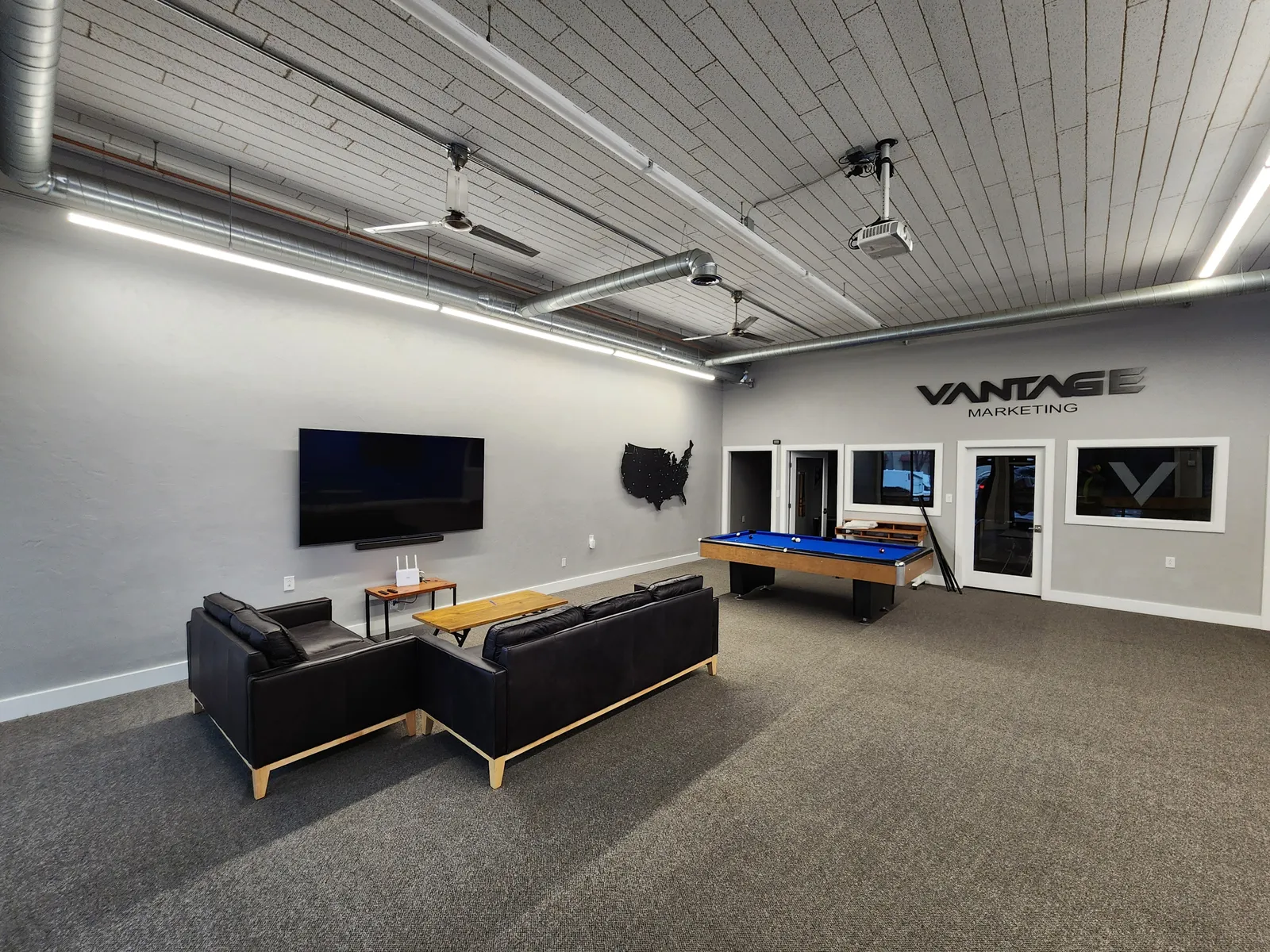 Commercial game room lounge area with couches and TV